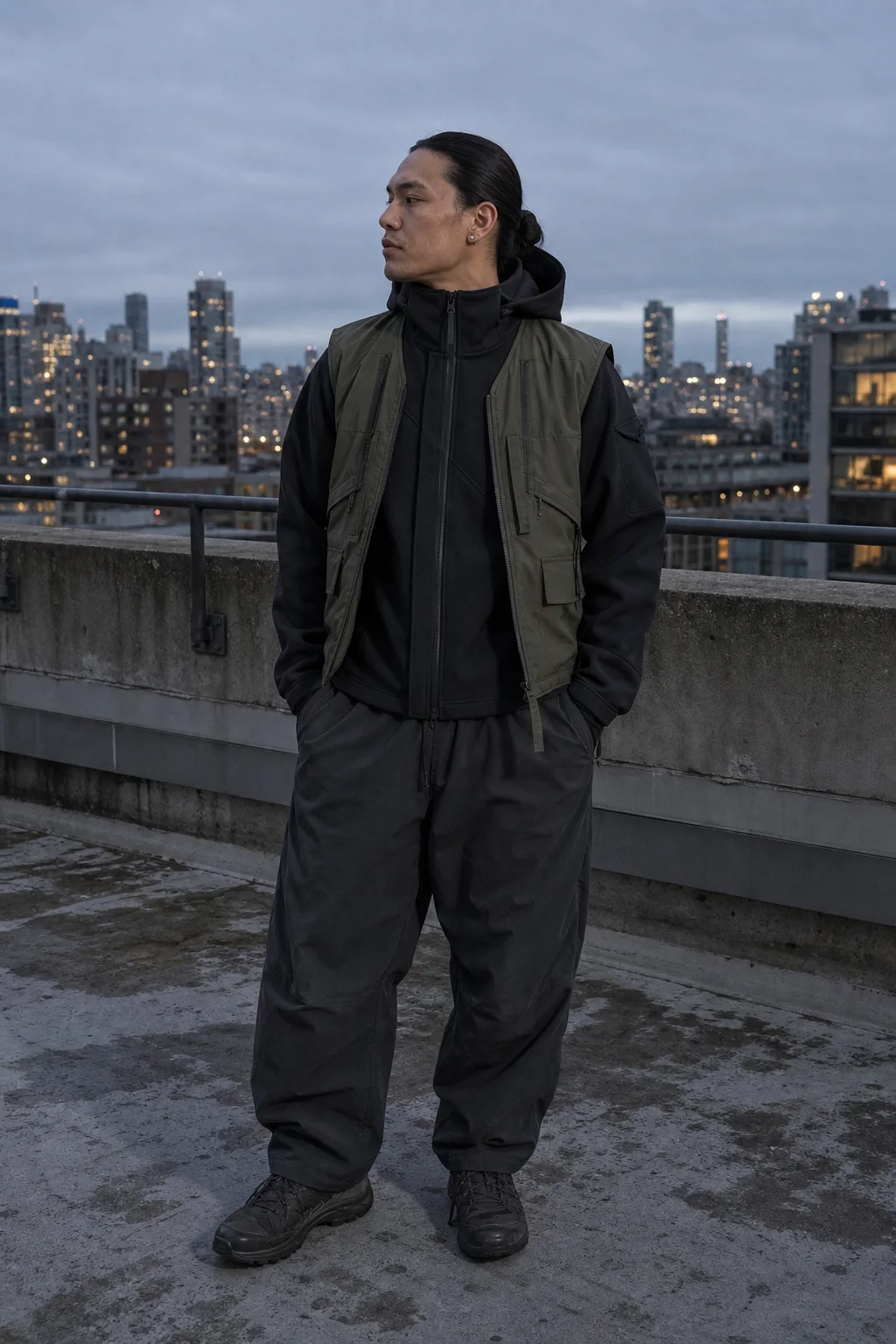 Vancouver rooftop styling image showing the Clothixpack CXP-H102 Signal Technical Hoodie under an olive utility vest with charcoal balloon pants.