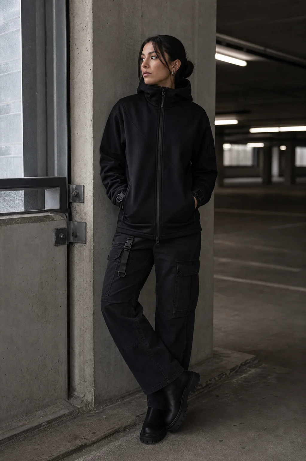 Berlin parking garage styling image showing the Clothixpack CXP-H103 Ridge Technical Hoodie with washed black cargo pants and lug boots.