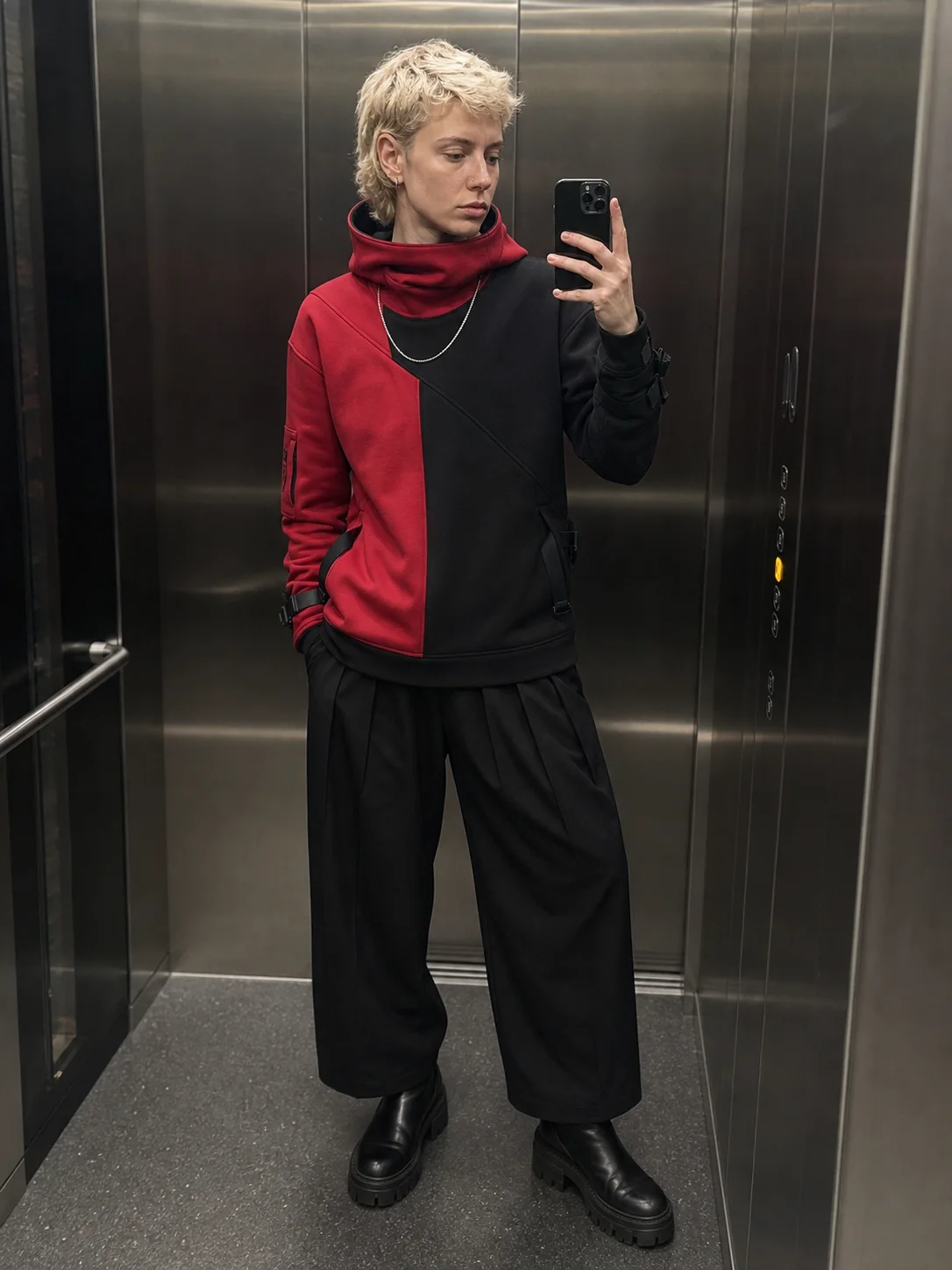Berlin elevator mirror styling image showing the Clothixpack CXP-H104 Cowl Technical Hoodie with black pleated trousers and lug boots.