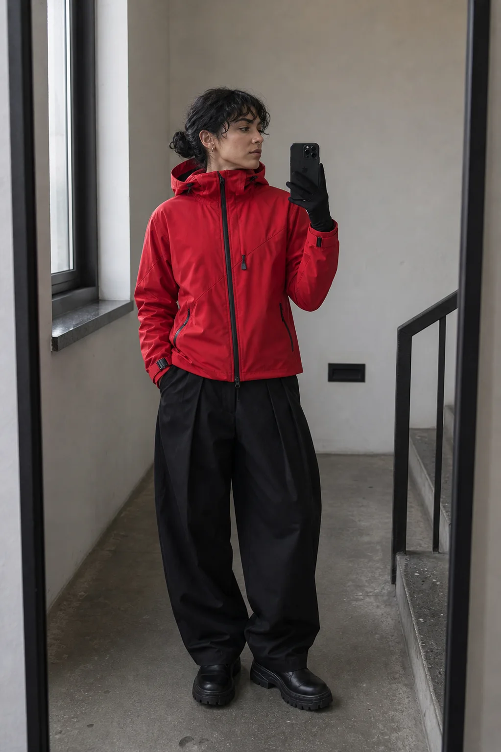 Berlin stairwell mirror styling image showing the Clothixpack CXP-J104 Ghost Hardshell Jacket with wide black pleated trousers.